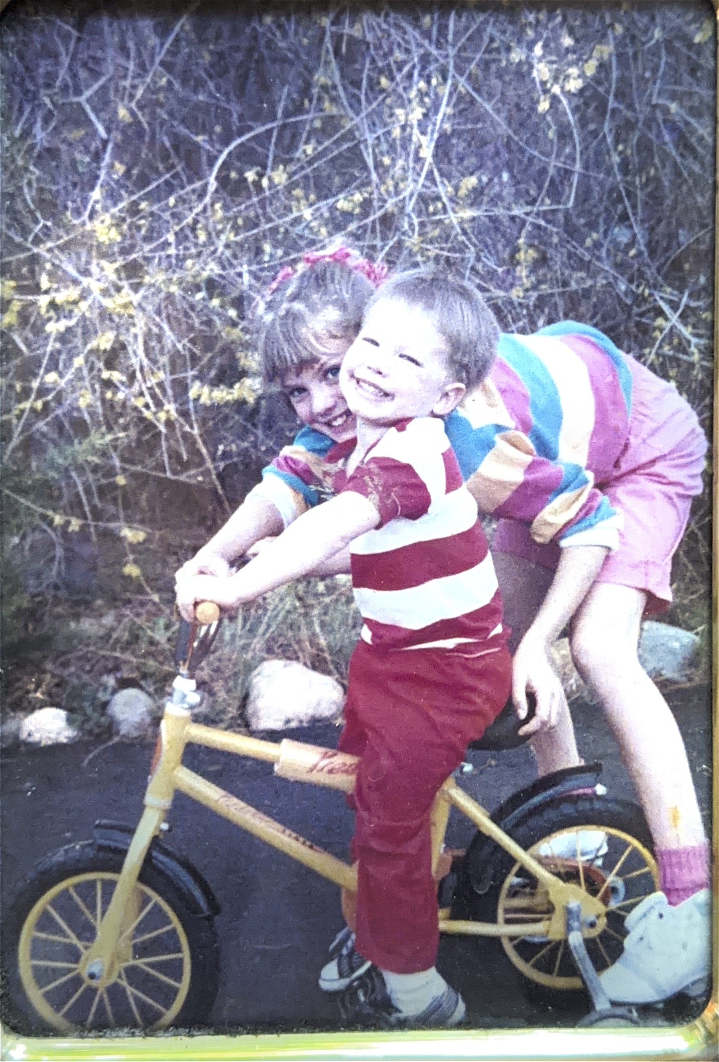Two children playing together on a bicycle